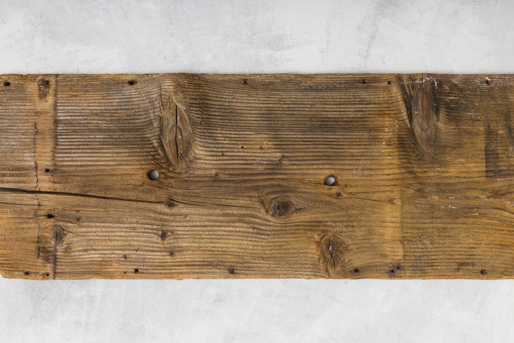 Płyta drewniana w ciemniejszym odcieniu z widocznymi sękami i strukturą drewna